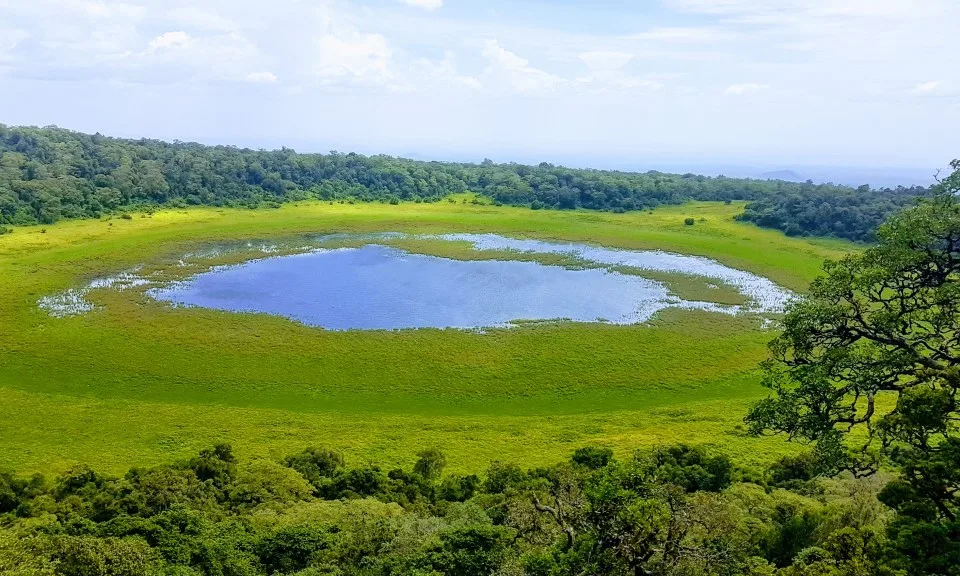 Marsabit's untamed wilderness: A stunning aerial view of a crater lake surrounded by lush green vegetation.
