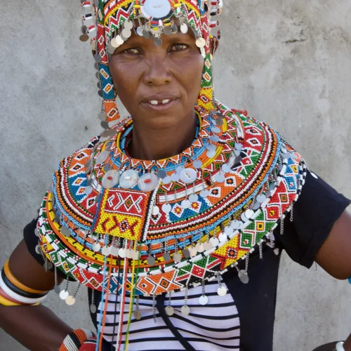Maasai woman wearing colorful traditional beaded jewelry and headpiece in Kenya