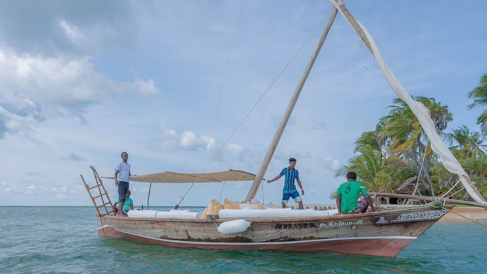 Traditional dhow boat sailing in the turquoise waters of Manda Bay, Lamu, Kenya