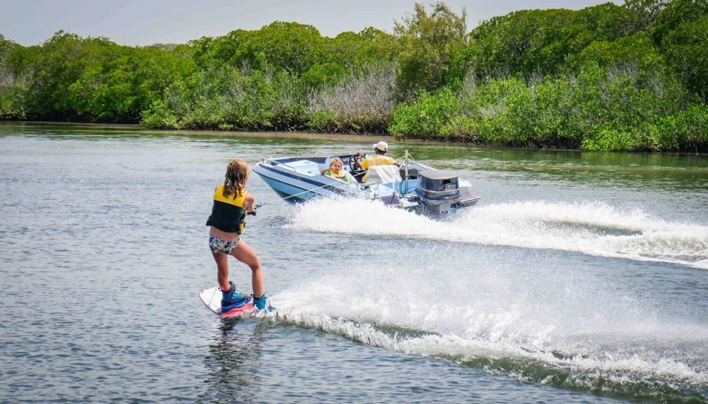 Woman water skiing behind a speedboat in Manda Bay, Lamu, Kenya